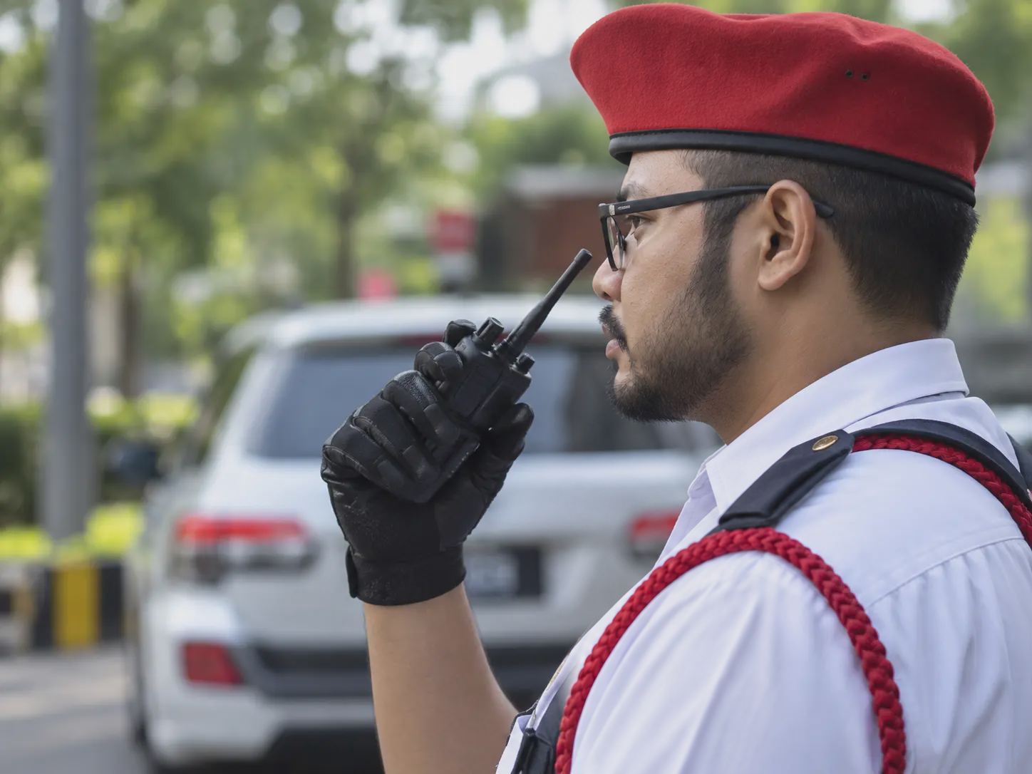 Security officer with a red beret using a two-way radio