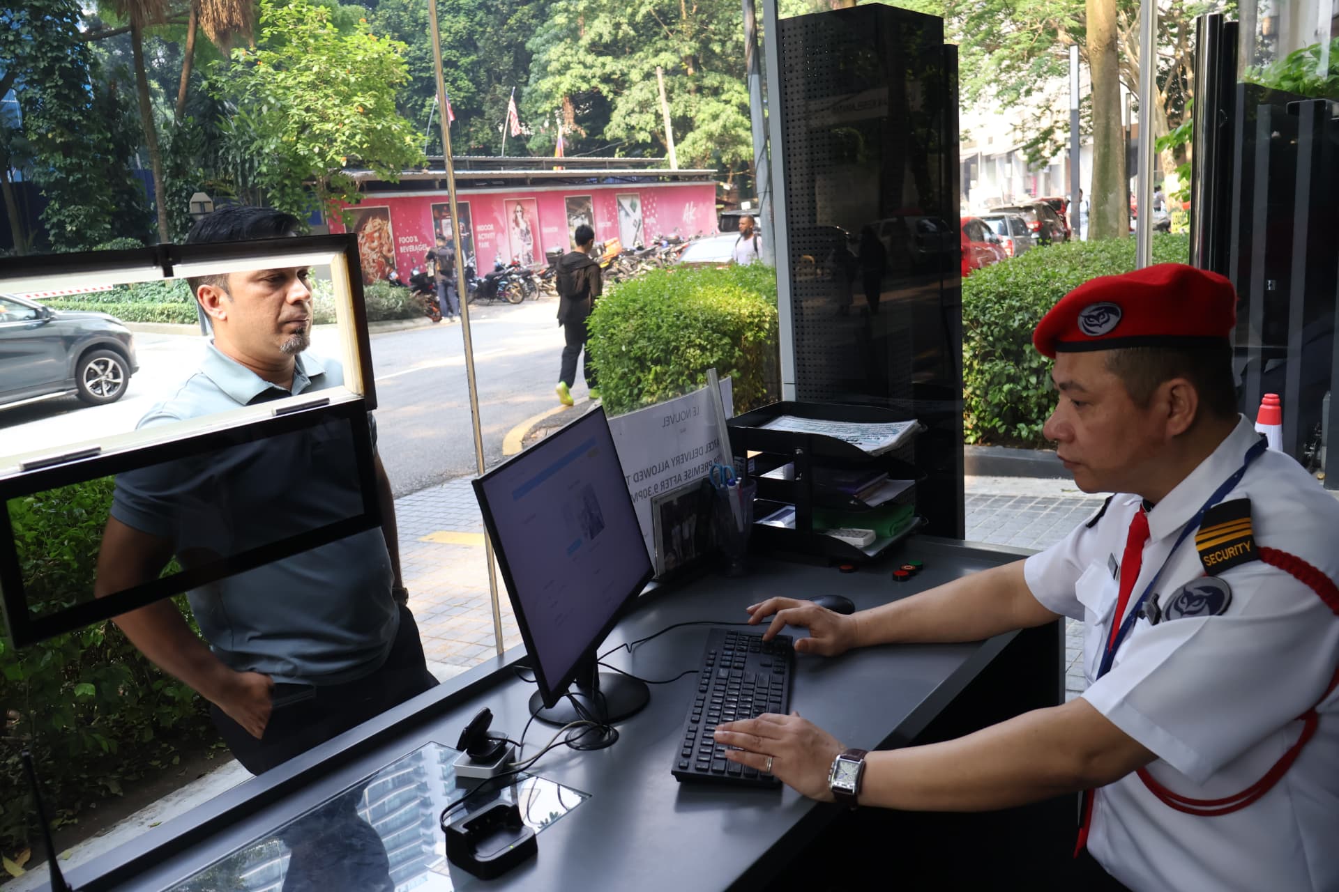 Kaliber security officer at the guard house desk assisting a visitor